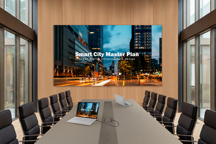 In a luxurious meeting room with a wide conference table, there is an LAAB installed on the wall. The LAAB screen vividly displays presentation materials for the meeting.